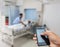Hand hold and touch screen smart phone, on blur image of A patient in the hospital with saline intravenous, in As