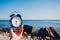 Hand hold watch on beach background.Alarm clock on sea and sand background different time with summer vacation.Vacation time conce