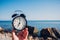 Hand hold watch on beach background.Alarm clock on sea and sand background different time with summer vacation.Vacation time conce