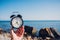 Hand hold watch on beach background.Alarm clock on sea and sand background different time with summer vacation.Vacation time conce