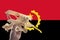 Hand holding airplane plane over Angola flag, travel concept