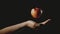 Hand holding an apple suspended in the air