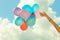 Hand holding balloons sky background
