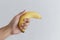 Hand holding banana, on white background