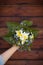 Hand holding a beautiful bunch of spring and summer flowers on old wooden background. Garden bouquet in a woman`s hand