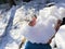 Hand holding a big mound of freshly fallen fluffy snow from the ground