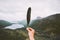 Hand holding bird feather moody weather mountains landscape aerial view