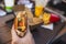 A hand is holding bitten hamburger. Tray with food on the background