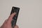 Hand holding black multimedia tv remote control