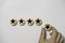 Hand holding black star which print screen on round wooden to give five stars for excellent evaluate after customer use product