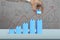 Hand holding blue block complete growth bar graph shape