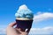 hand holding blue velvet cupcake against sky