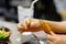 Hand holding bone of Roasted chicken leg, Bitten eaten deep fried crispy chicken wing in restaurant