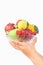 Hand holding bowl of fruits