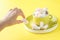 Hand holding bowl of sweet Marshmallow pastel isolated on yellow