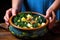 hand holding a bowl of zuppa toscana towards the camera