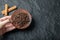 Hand holding a brown plate with dried clove