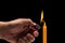 Hand holding burning gas lighter to light candle. Studio shot is