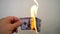 Hand holding a burning hundred dollar banknote