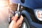 Hand holding button on the remote car. In selective focus of woman hand presses on the remote control car alarm systems.