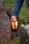 Hand holding a candle to light a grave lantern