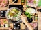 Hand holding chopsticks eating.Sukiyaki and shabu soup with Dumplings, white cabbage, crab, vermicelli, shrimp