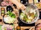 Hand holding chopsticks eating.Sukiyaki and shabu soup with Dumplings, white cabbage, crab, vermicelli, shrimp, and in a white cup