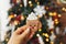 Hand holding christmas gingerbread cookie and decorations at christmas tree  gingerbread cup