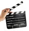 A hand holding a clapper board