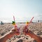 Hand holding cocktail with garbage on background of clean beach, ocean waves. Plastic ocean pollution, environmental crisis. Say