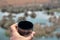 A hand holding a coffee pot filled with arabic coffee