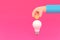 Hand holding a coin with a light bulb knowledge accumulation concept