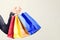 Hand holding color shopping bags. Seasonal sale, shopping time, consumerism, and advertisement. Black friday concept, copy space