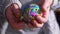 Hand holding colorful rubber band ball