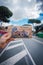 Hand holding Colosseum postcard in Rome street scene