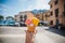 Hand holding cone with colorful delicious italian gelato ice-cream in Menaggio town near Como lake