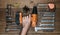 hand holding Cordless screwdriver and tool kit on an old wooden table