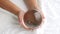 Hand holding a crystal glass ball transparent on white fabric background.