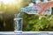 Hand holding drinking water bottle pouring water into glass on wooden table