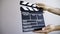 Hand holding empty film making clapperboard  on white background