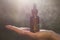 Hand holding essential oil, bottle - blurred background