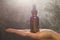 Hand holding essential oil, brown bottle