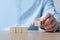 Hand holding four blank wooden cubes, business concept background, mock up, template