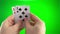 Hand holding four eights on a green background close-up female hands with French manicure. Woman sorts through cards