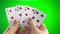 Hand holding four sixes on a green background close-up female hands with French manicure woman sorts through the cards