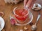 A hand holding a full teacup. Red tea with spices on a blurred wooden background. A traditional red tea for breakfast.