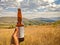 Hand holding a glass beer beverage outdoors, Sierra Madre del Sur mountains in the background. Travel in Mexico