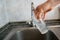 hand holding a glass and pouring pure water in to drink