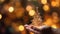 Hand holding golden christmas tree on bokeh lights background