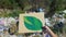 Hand holding green leaf painting on cardboard against open dumping, ecology